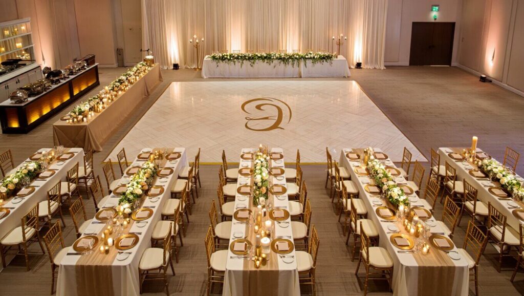 wedding reception with long rectangular tables arranged around a central dance floor