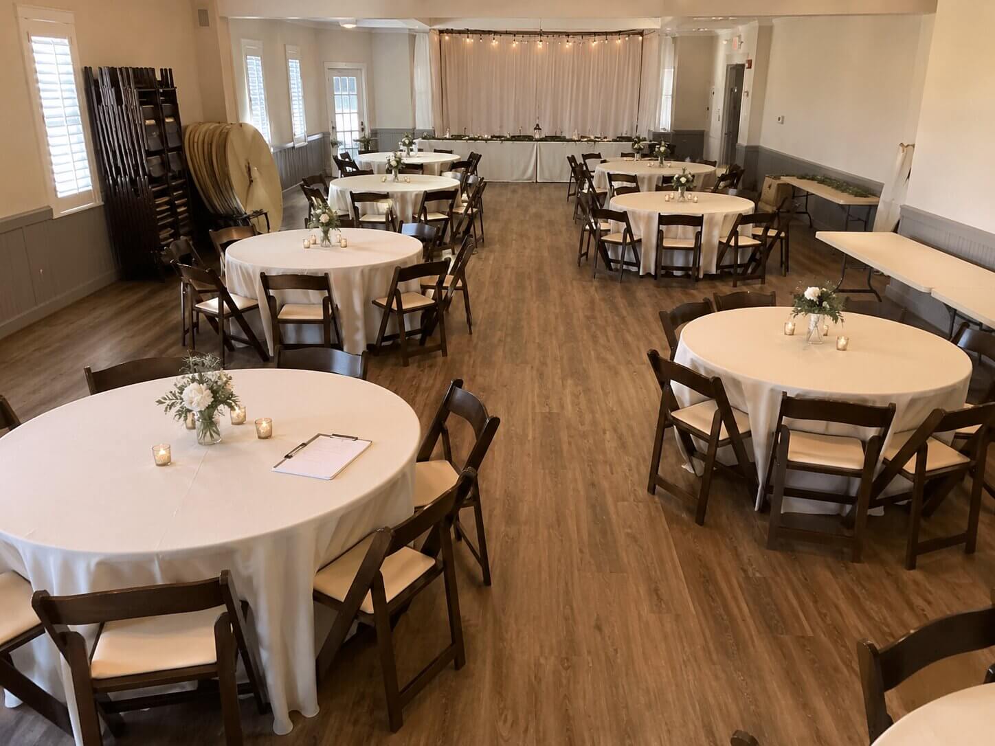 Small wedding reception setup with round tables and clear walkways