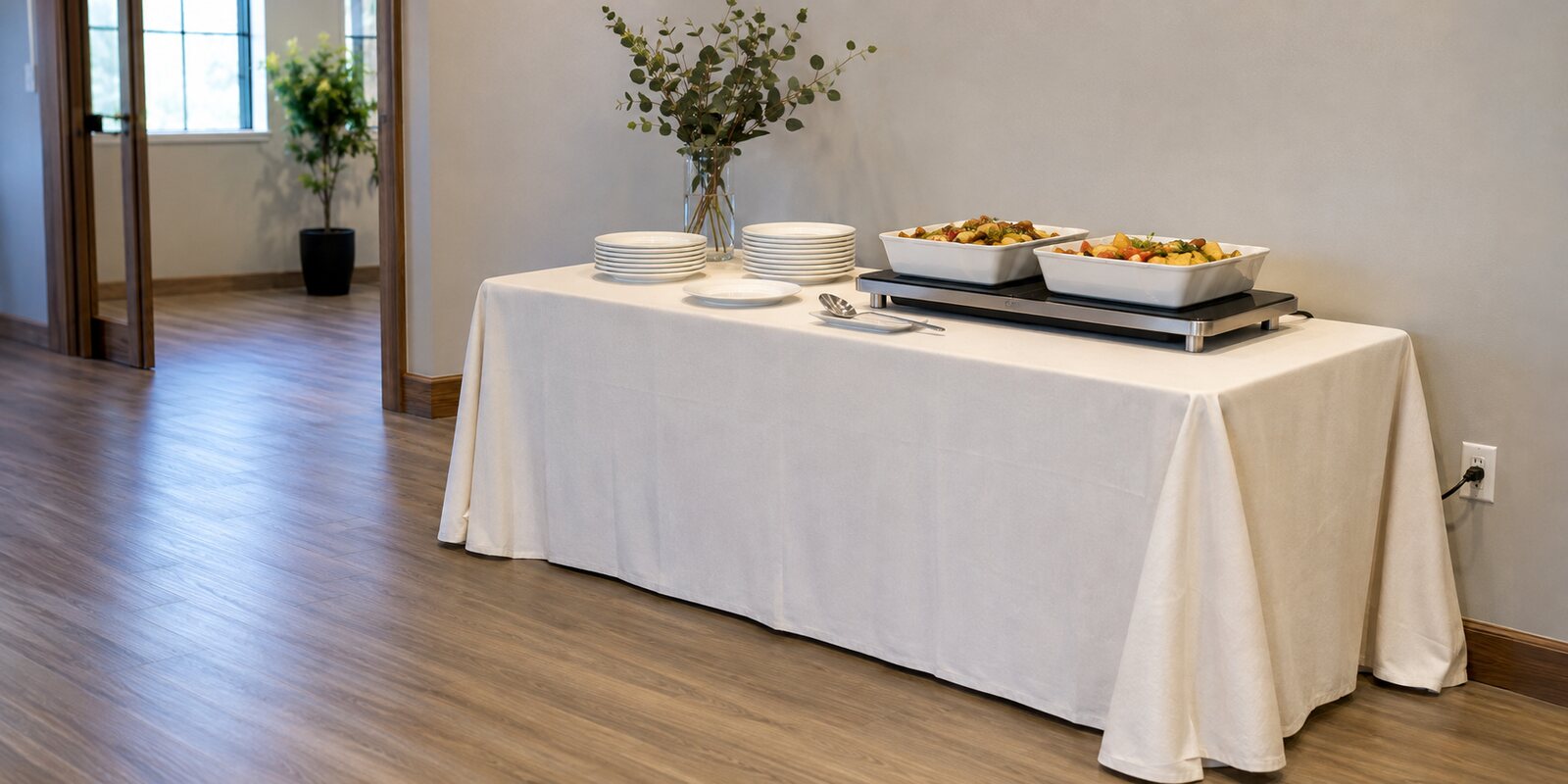 Buffet table with food warmers and a clear cord-free guest path