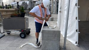 Installer securing a frame tent with concrete weights