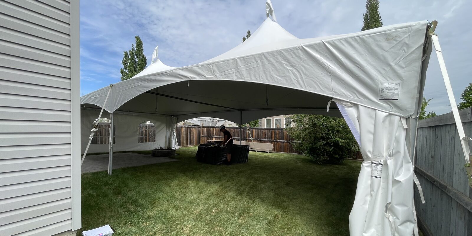 GPLANN frame tent being installed on grass beside a house